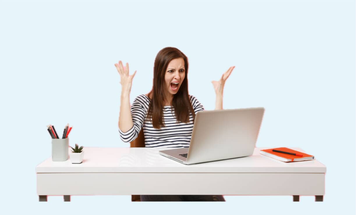 Eine junge wütende Frau hat Probleme mit ihrem Laptop und breitet ihre Hände aus.